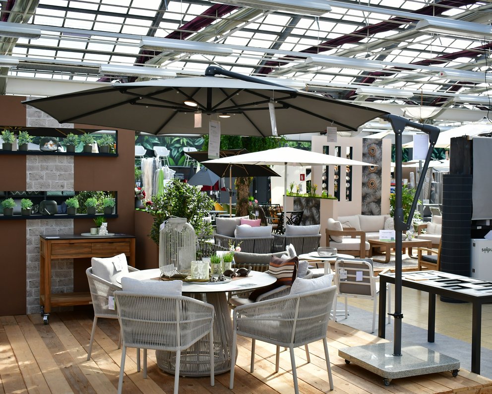 Gartenmöbel, die unter einem Ampelschirm stehen.