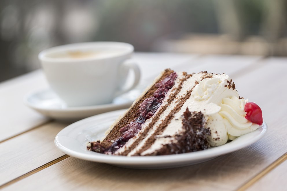 Ein Stück Schwarzwälder Kirschtorte liegt auf einem Kuchenteller