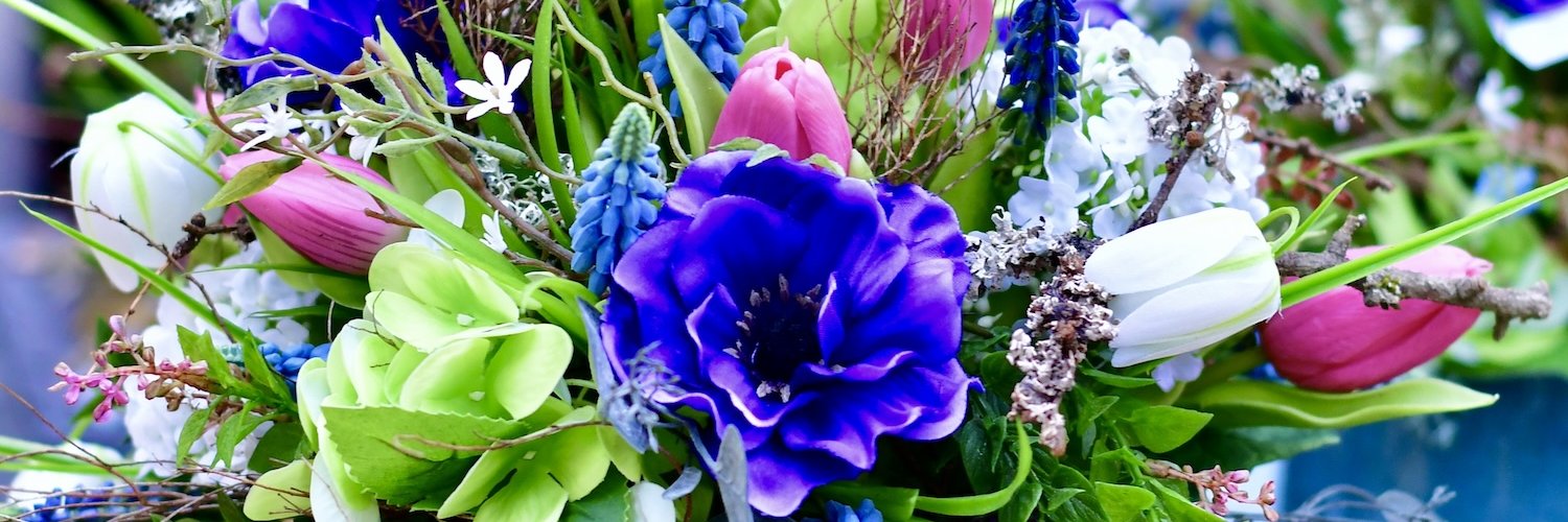 Blumenarrangement aus Seidenblumen in bunten Frühlingsfarben