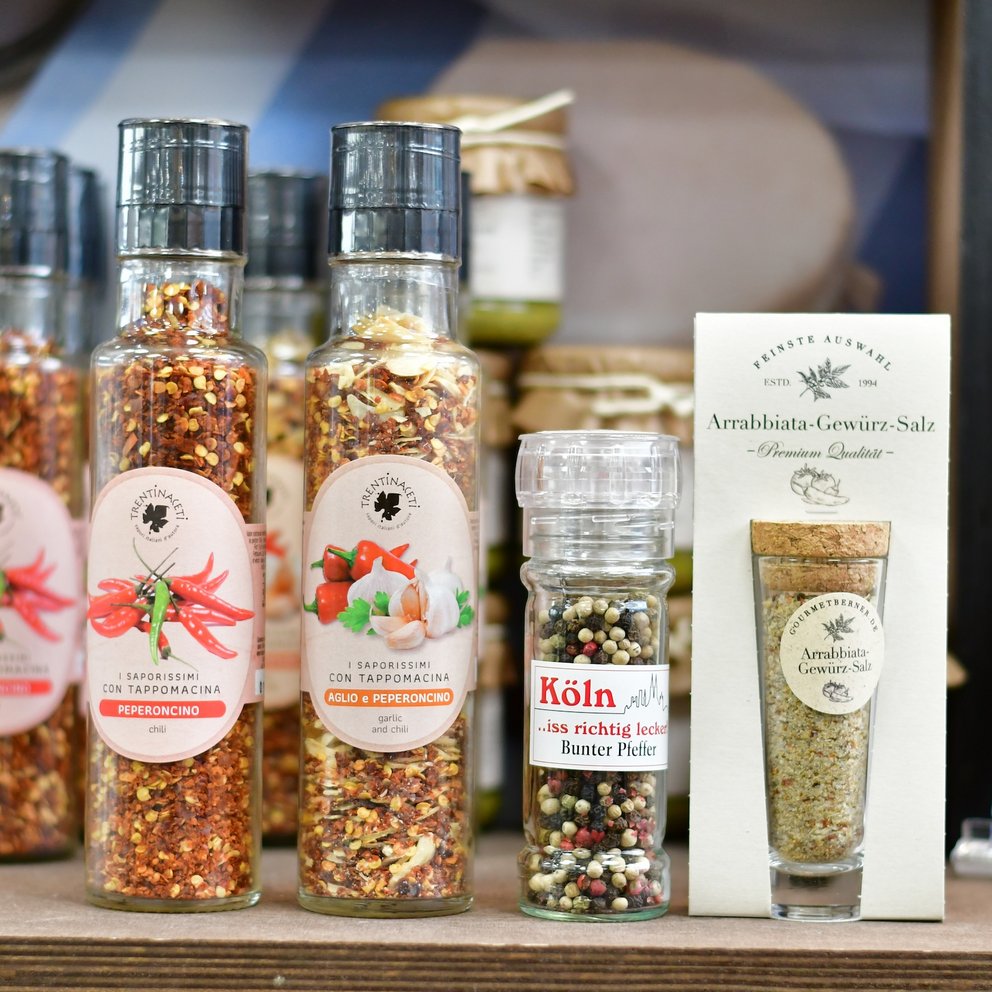 Verschiedene Gewürze in Mühlen im Regal