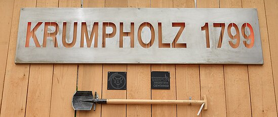 Schriftzug Krumpholz 1799 mit Spaten darunter