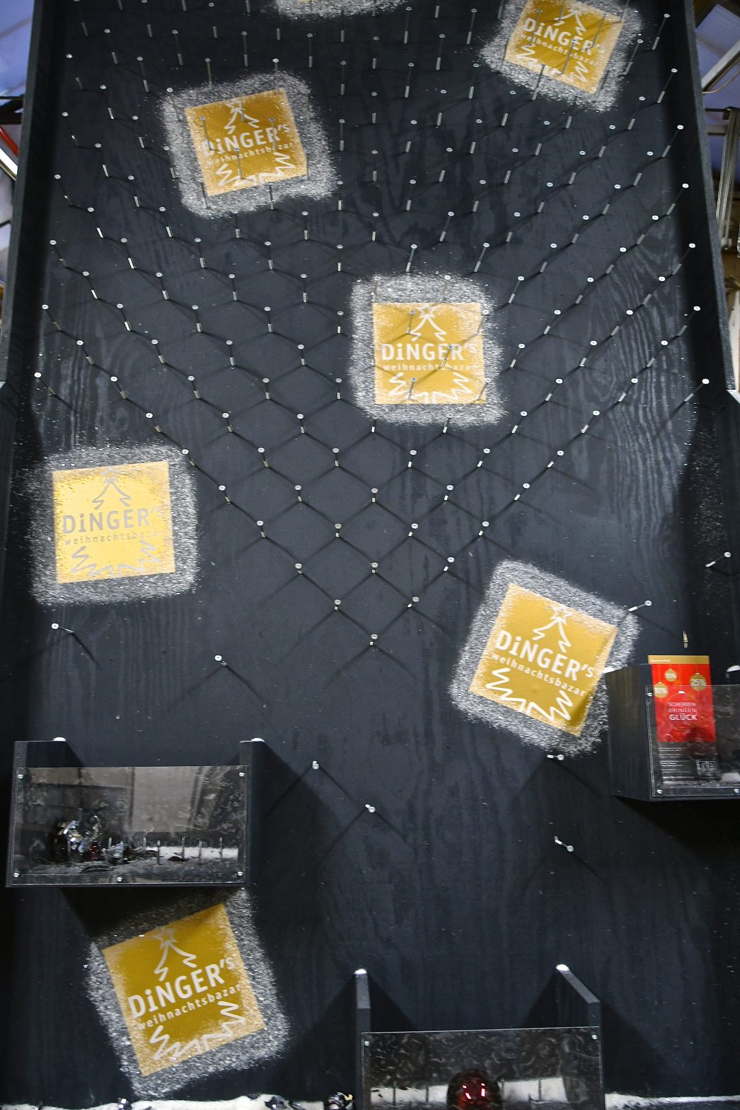 Scherben bringen Glück Rabatt-spiel graue Holzwand mit vielen Schrauben und Logos des Dinger’s Weihnachtsbazar.