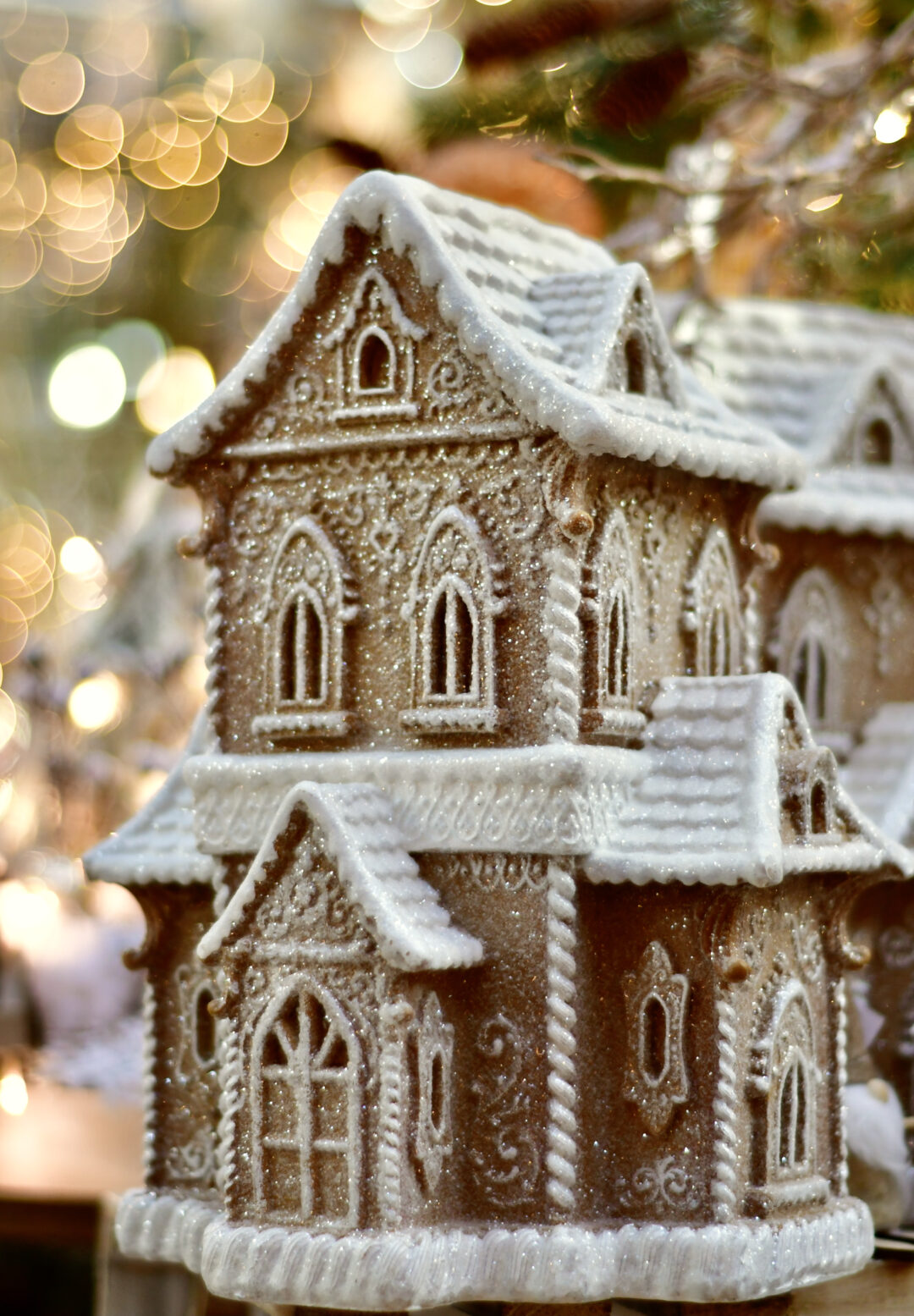Ein Haus in Lebkuchen-Optik aus unserem Weihnachtsbazar vor einem unscharfen Hintergrund mit Bokeh Effekt.