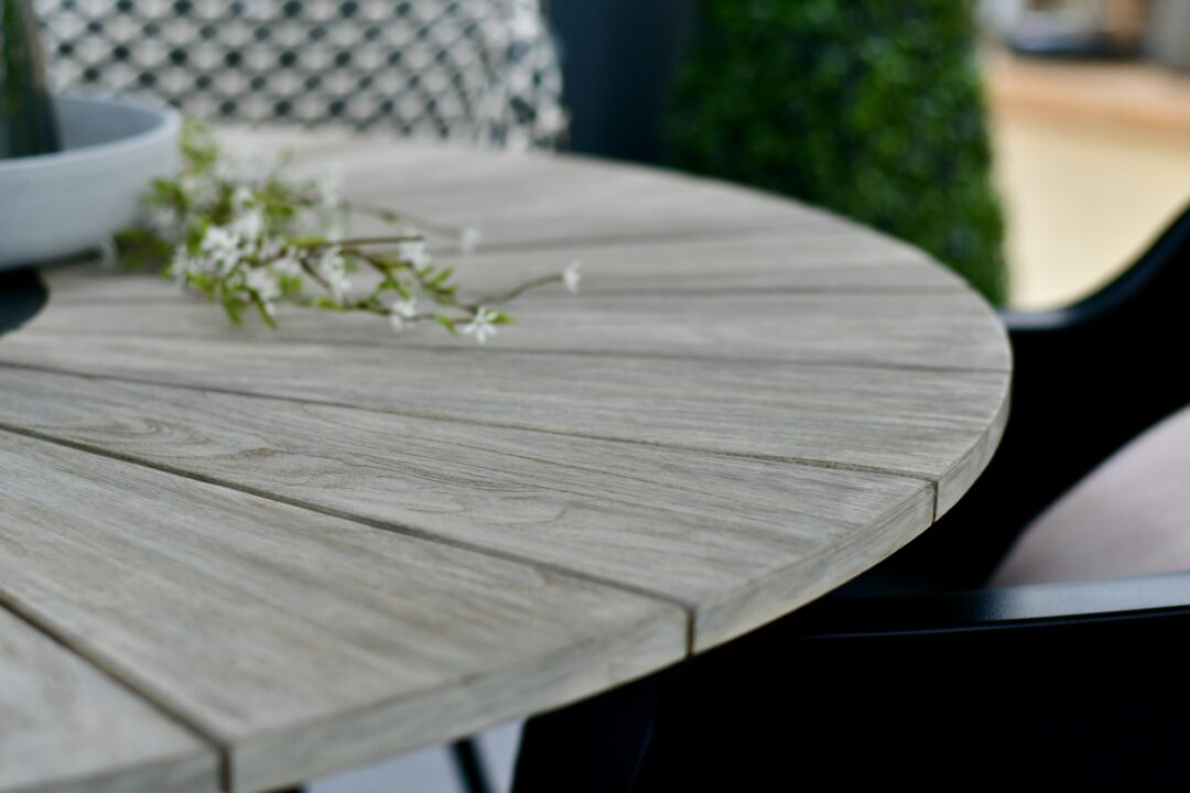 Tischplatte aus vorgegrautem Teak-Holz.