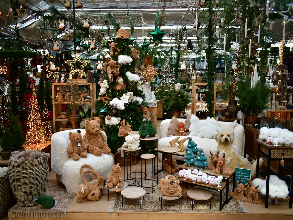 Geschmückter Baum mit Kuscheltieren und Sesseln drumherum