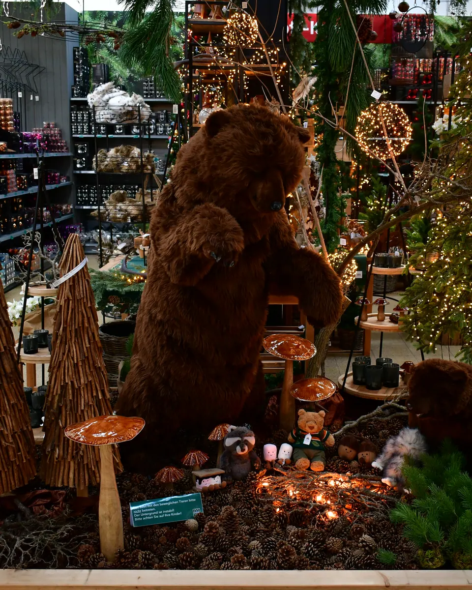 Großer Braunbär zwischen Weihnachtsdeko im Weihnachtsbazar