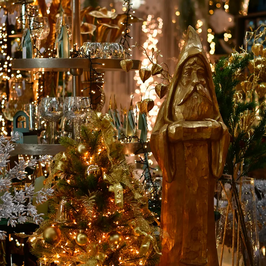Geschmückter Baum mit Gold und Lichtern im Weihnachtsbazar