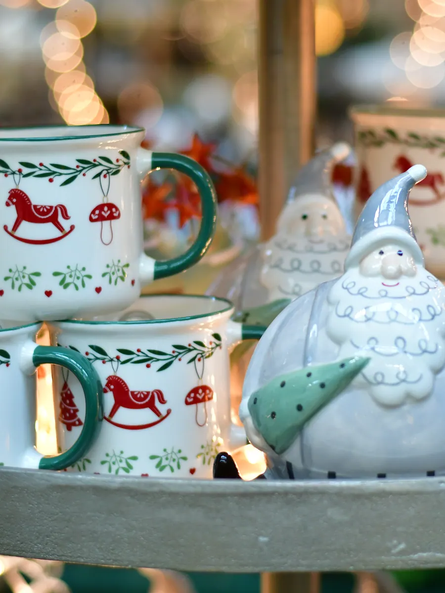 Weihnachtstassen mit Schaukelpferd-Motiv und Weihnachtsmann-Figur im Weihnachtsbazar