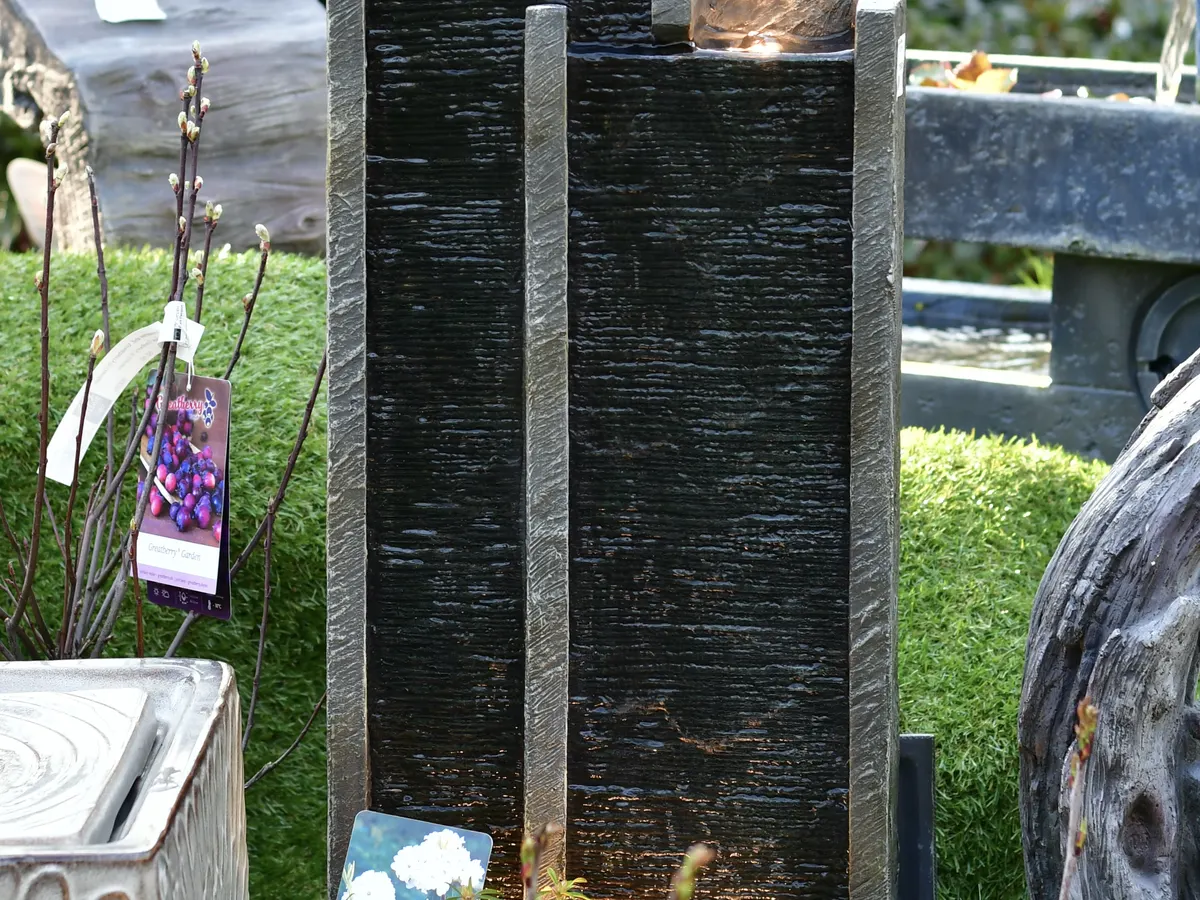 Moderne Wasserwand aus dunklem Stein