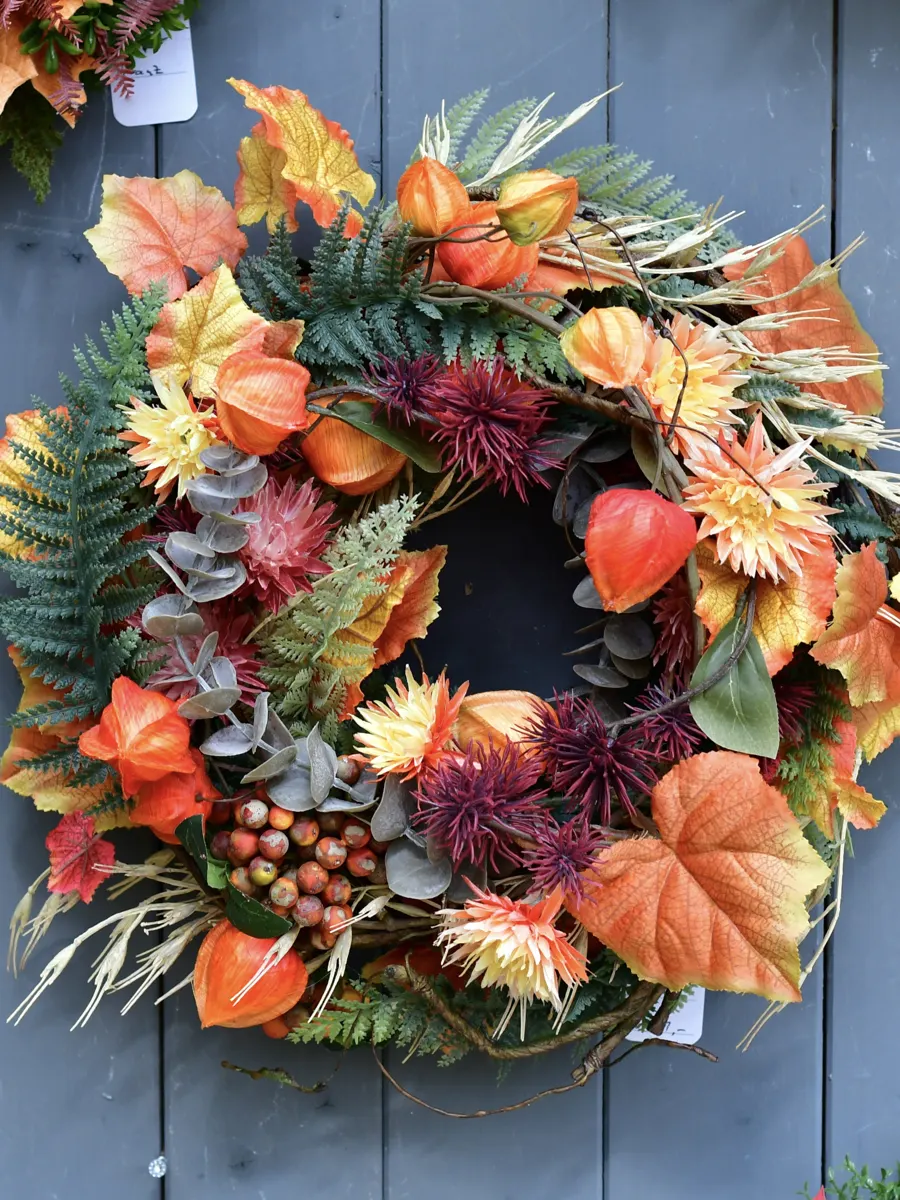 Herbstkranz in Orange mit Physalis, Blättern und Farn