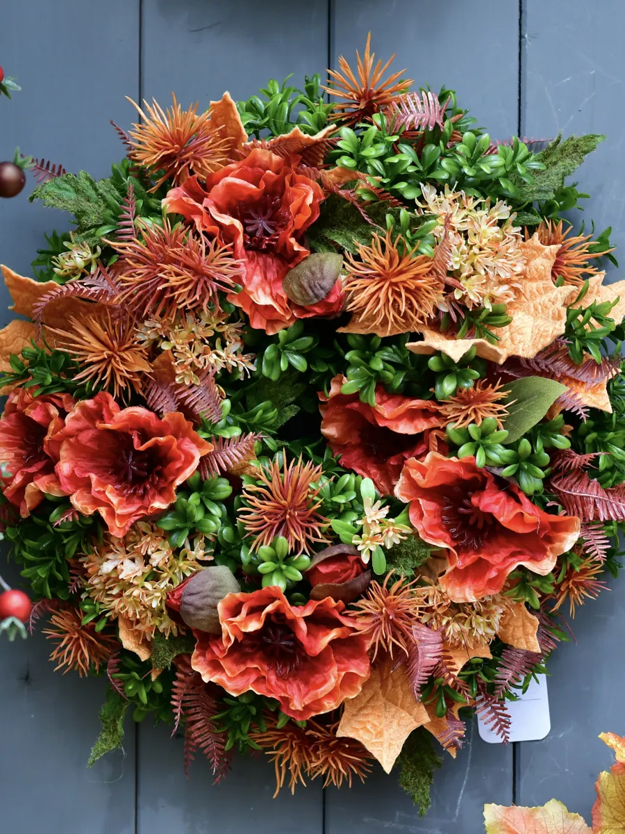 Kranz in Rot und Orange mit Blüten und Blättern