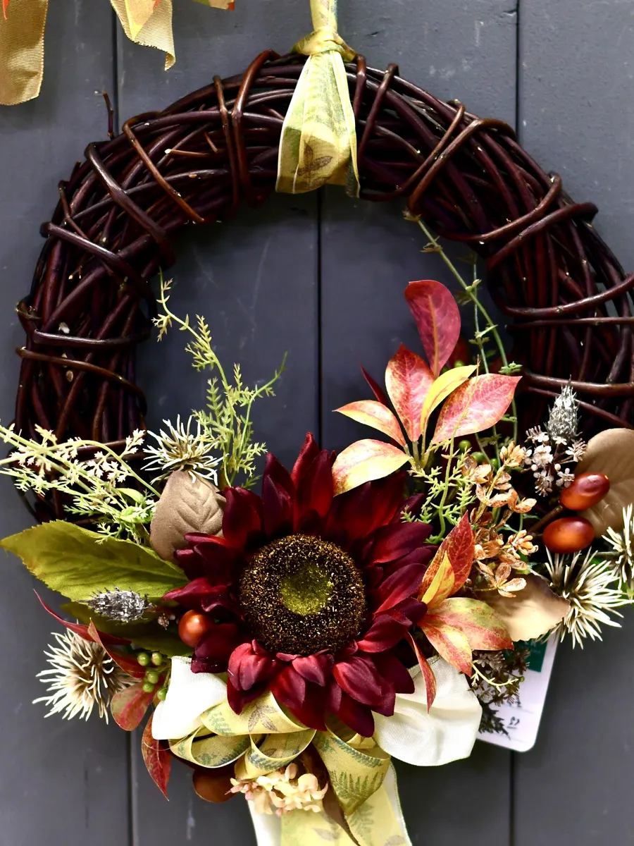 Weidenkranz mit dunkelroter Sonnenblume und Herbstlaub