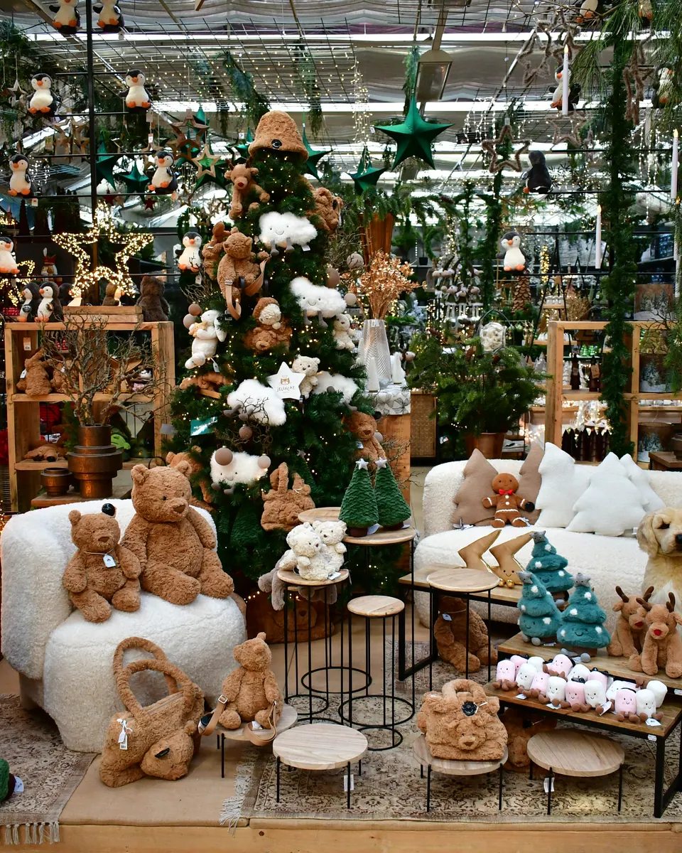 Weihnachtlich geschmückte Ecke mit Kuscheltieren, Sesseln und Baum