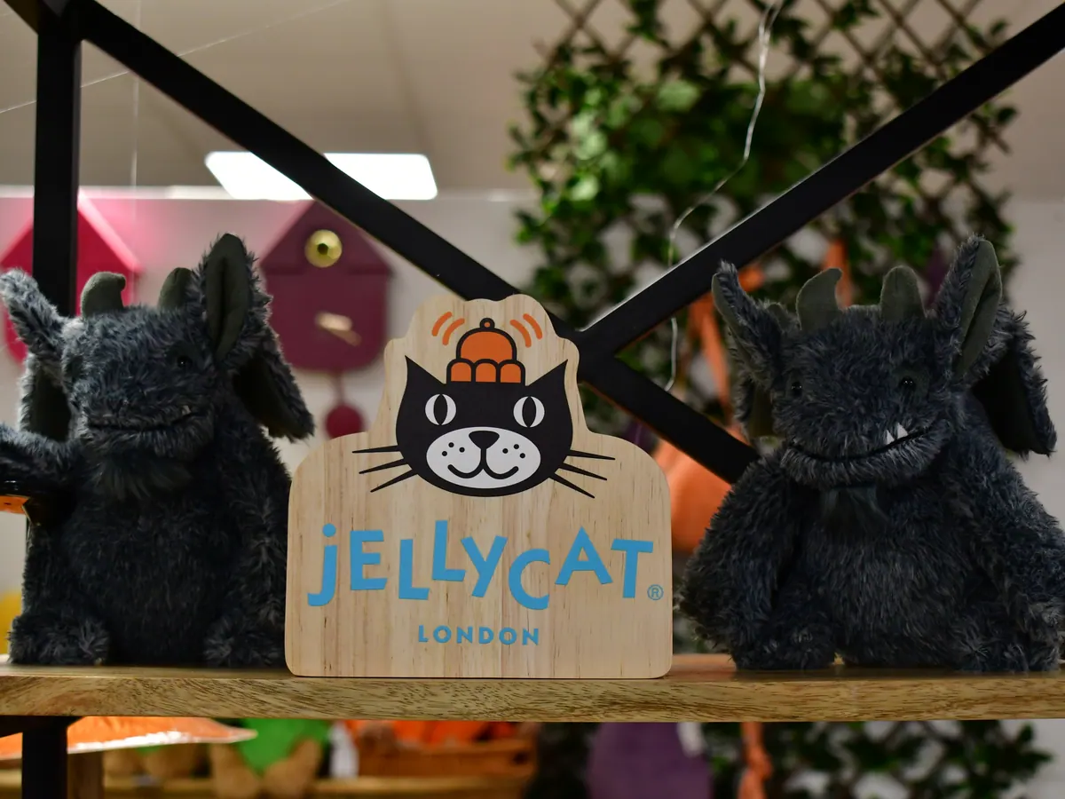 Schwarze Plüschfiguren neben einem Jellycat-Schild