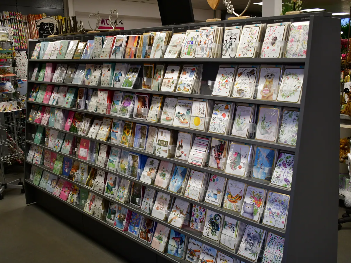 Lange Kartenwand mit Grußkarten in vielen Farben