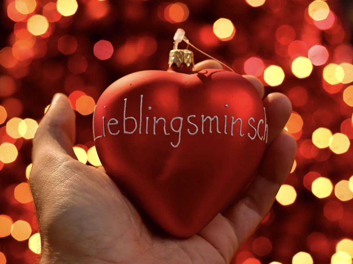 Rotes Kugelherz mit der Aufschrift Lieblingsminsch in einer Hand
