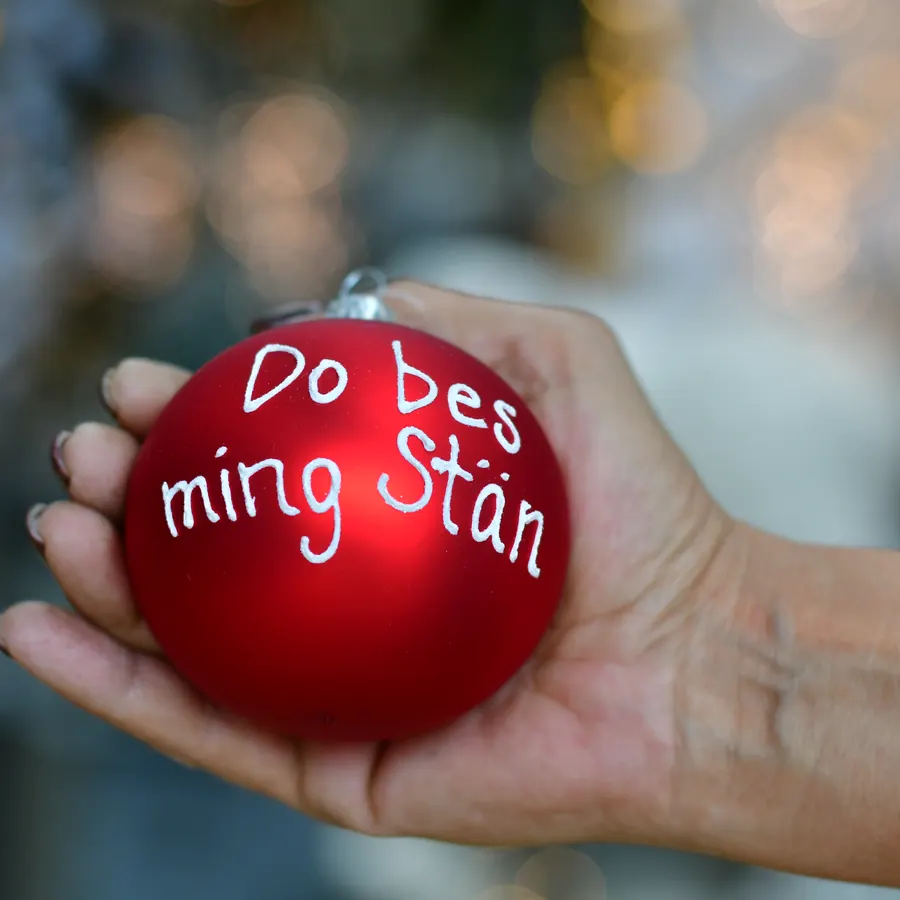 Rote Weihnachtskugel mit der Aufschrift Do bes ming Stän in einer Hand