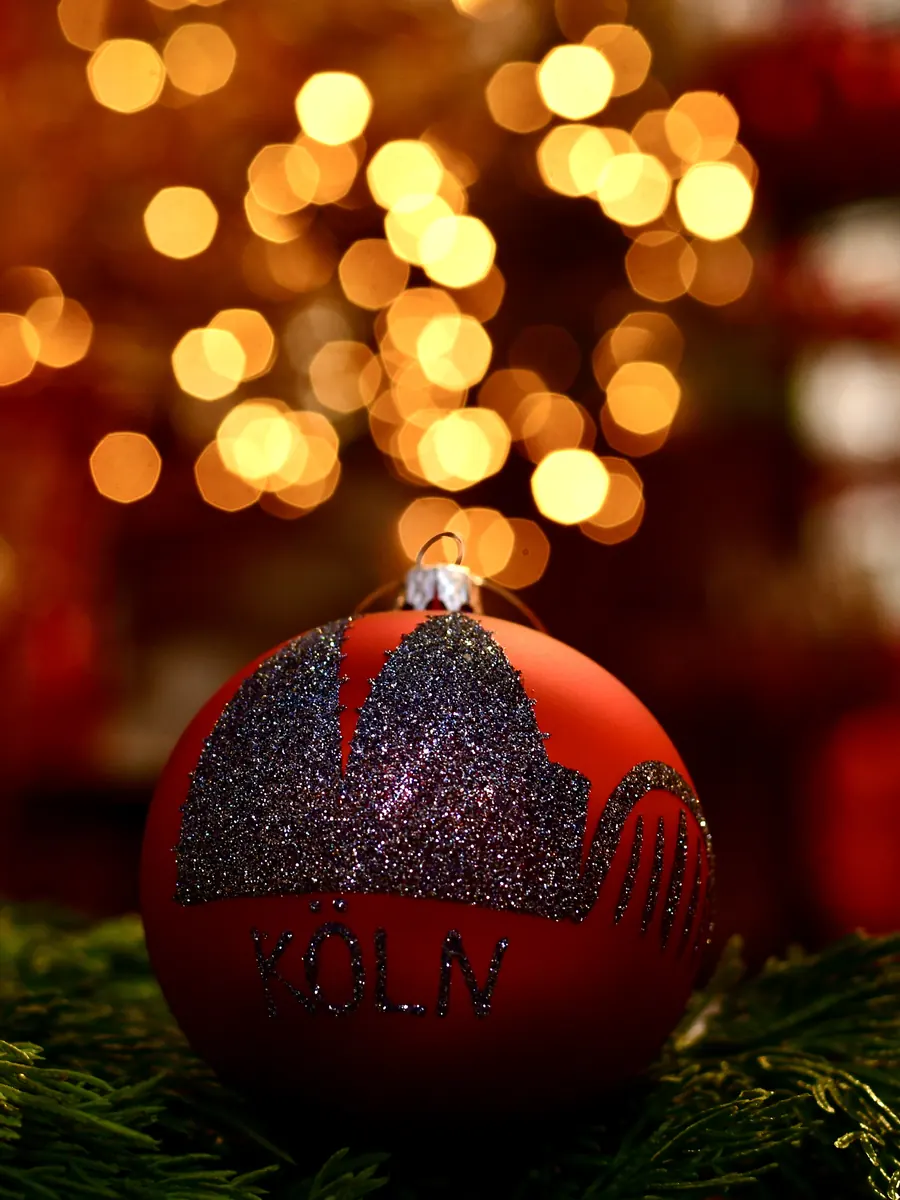 Rote Weihnachtskugel mit glitzernder Kölner Skyline und dem Schriftzug Köln