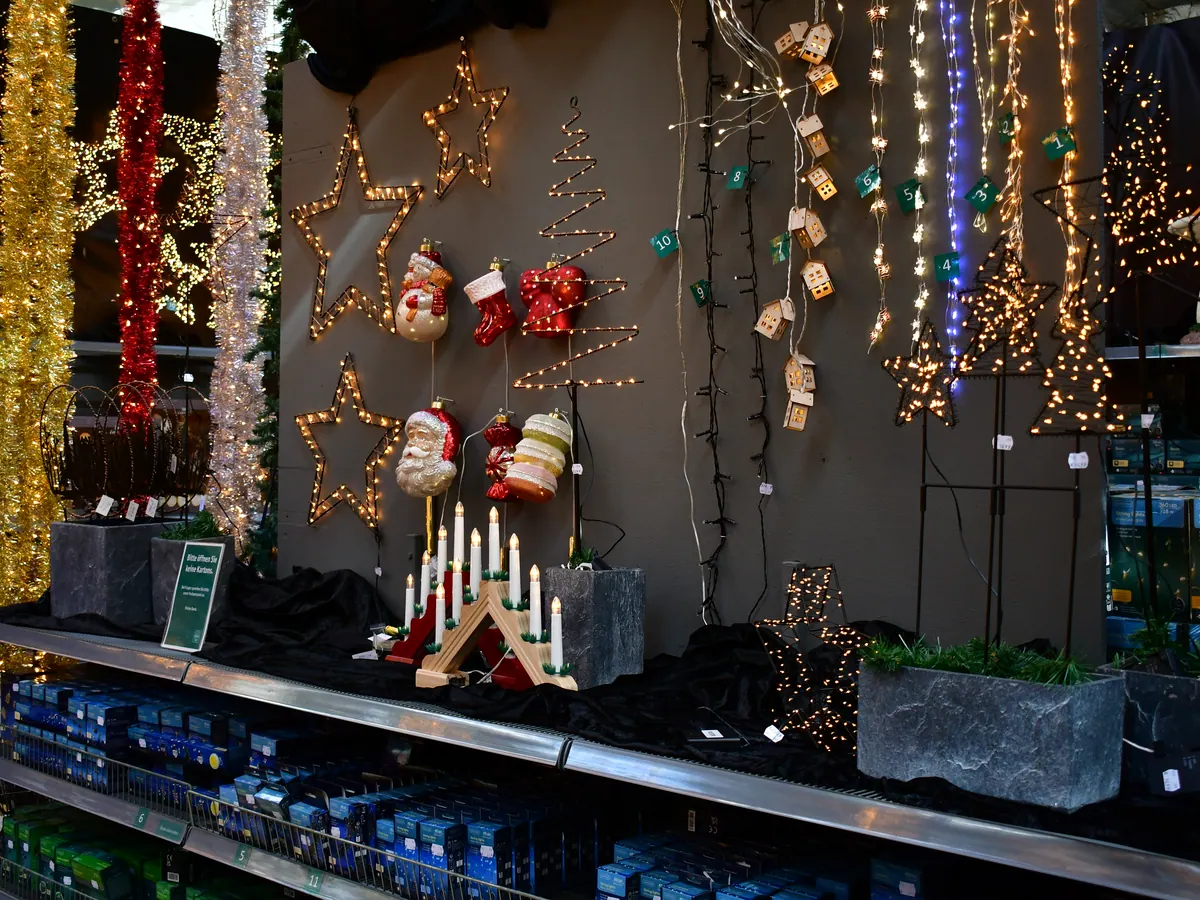 Wand mit Lichterketten, Leuchtsternen und Schwibbogen