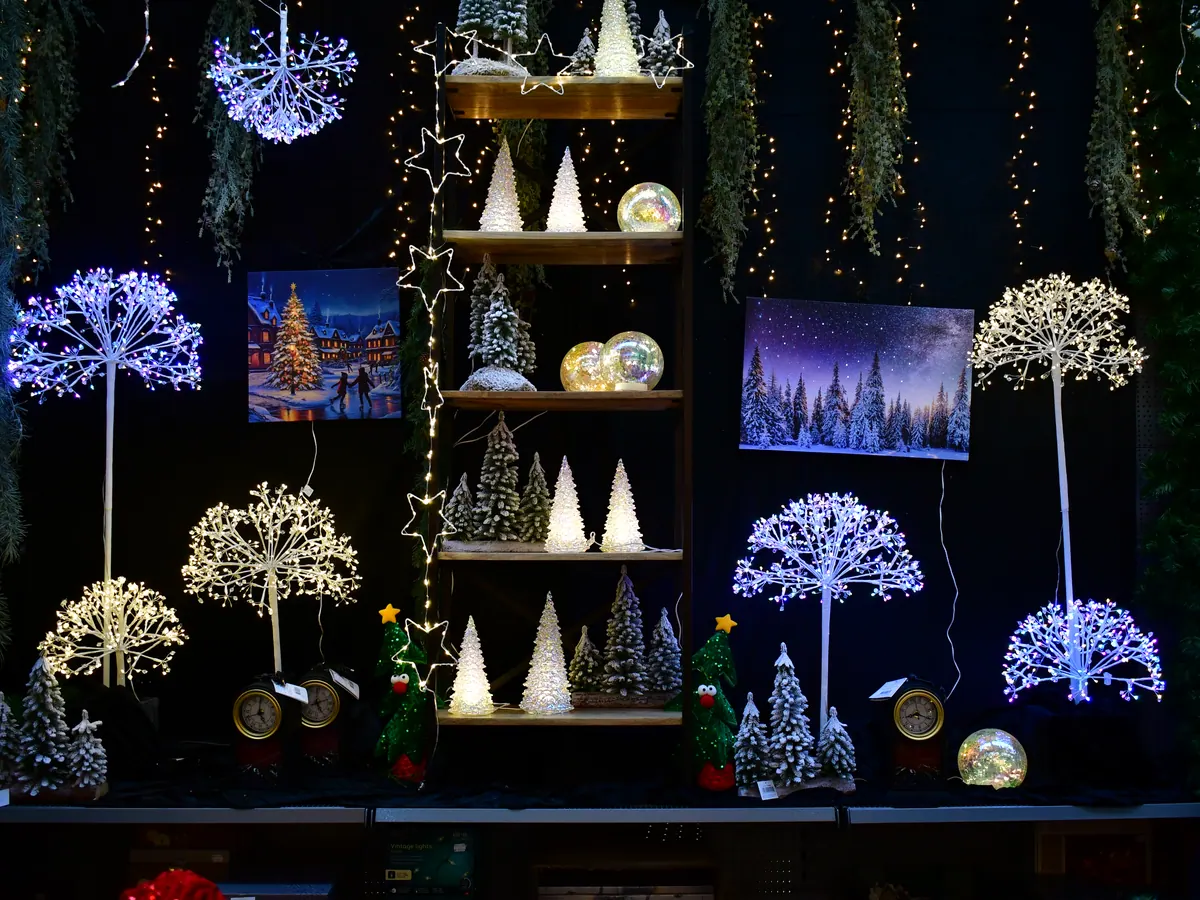 Leuchtende Deko-Bäume und Lichterfiguren auf dunklem Hintergrund
