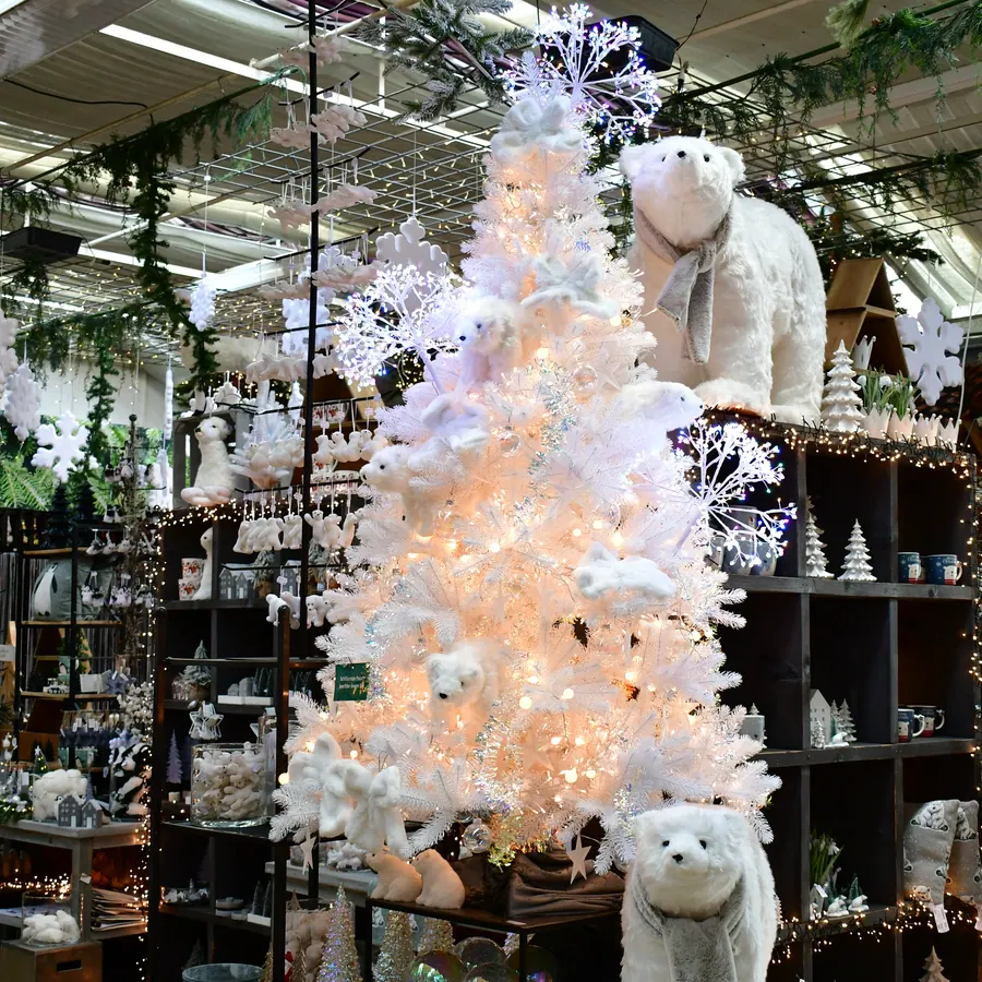 Weißer Themenbaum mit Lichterkette im Weihnachtsbazar