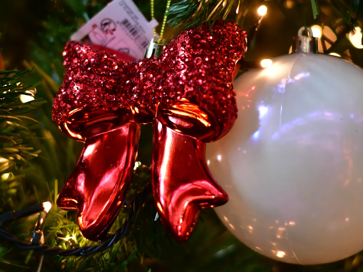 Rote Glitzerschleife an einem geschmückten Weihnachtsbaum