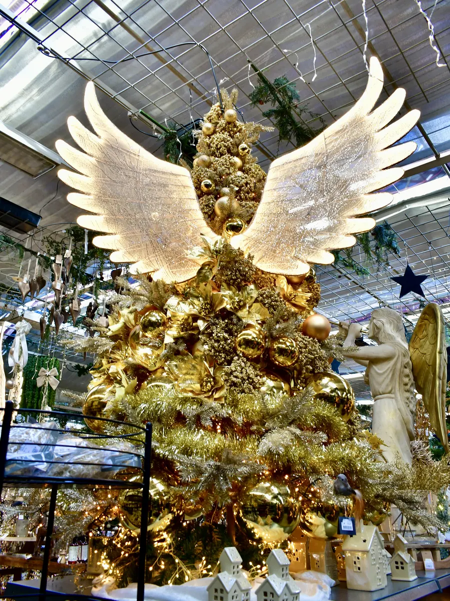 Goldener Themenbaum mit leuchtenden Engelsflügeln im Weihnachtsbazar