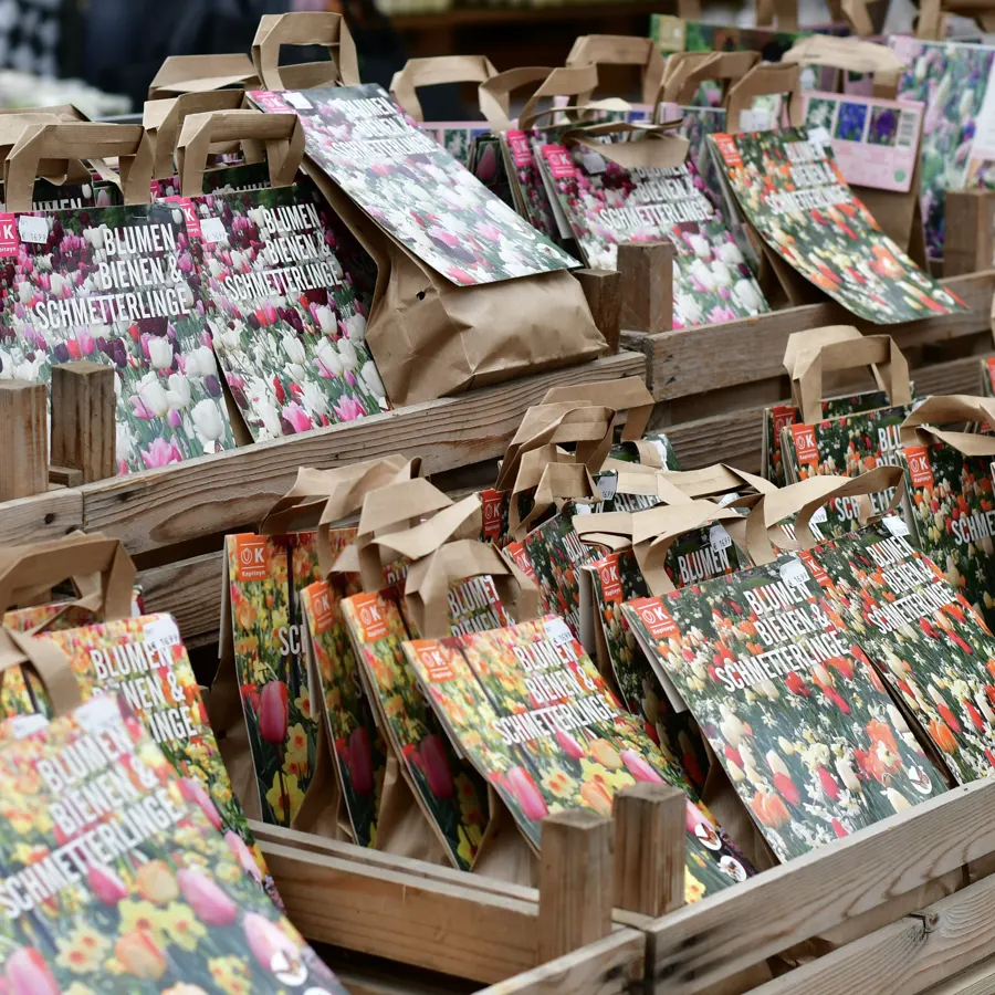 Tische mit bunt bebilderten Tüten voller Blumenzwiebeln